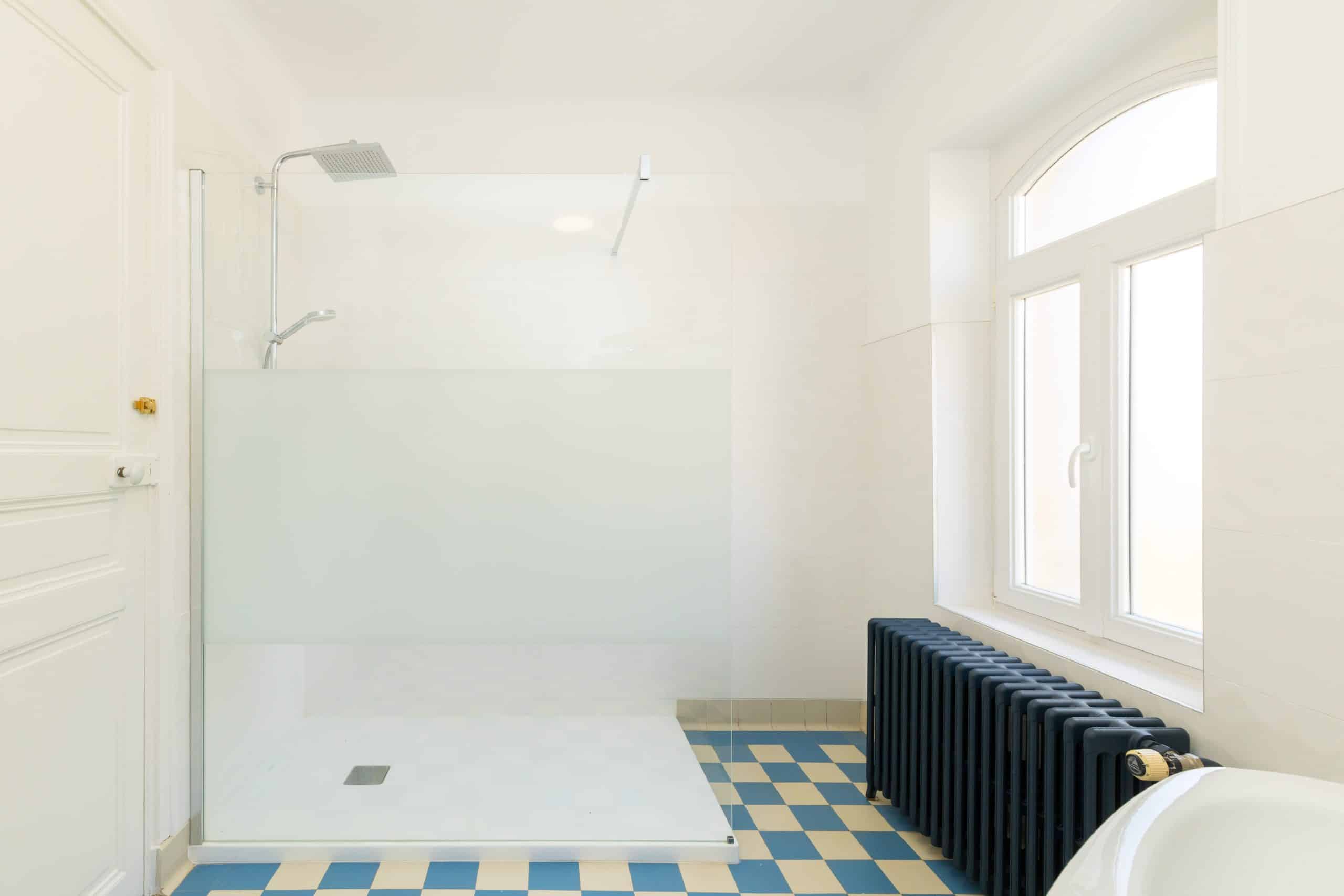 Douche à l'italienne, carrelage damier bleu/blanc, paroi vitrée